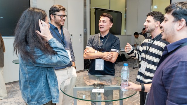 Attendees talking in small groups at a Mobile Guild event